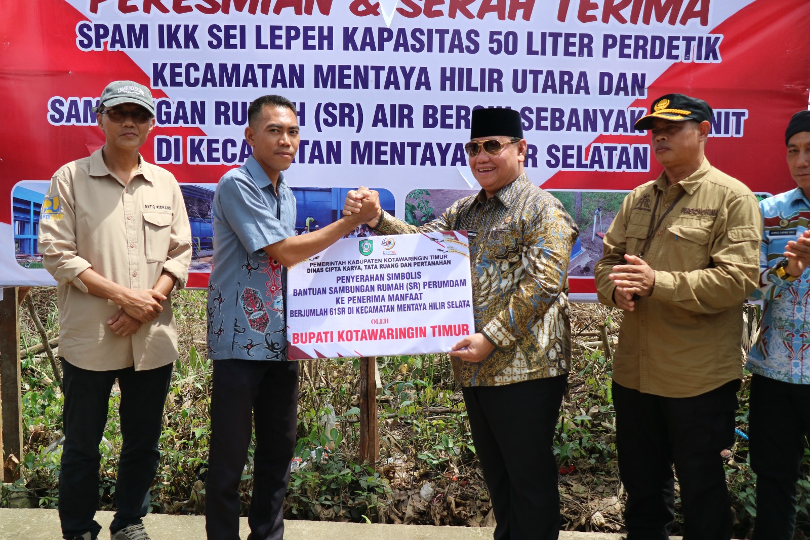 <p>Bupati Kotim, H Halikinnor saat menyerahkan secara simbolis kepada penerima manfaat SR Perumda, di Kecamatan Mentaya Hilir Selatan, Kamis (16/1/2025). </p>