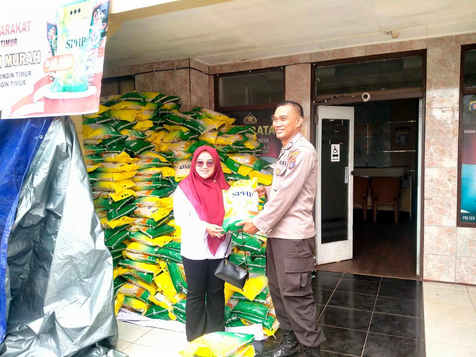 <p>Anggota Polsek Parenggean melayani warga yang membeli beras murah saat gelar pangan murah di Mapolsek setempat. (Foto : Ist).</p>