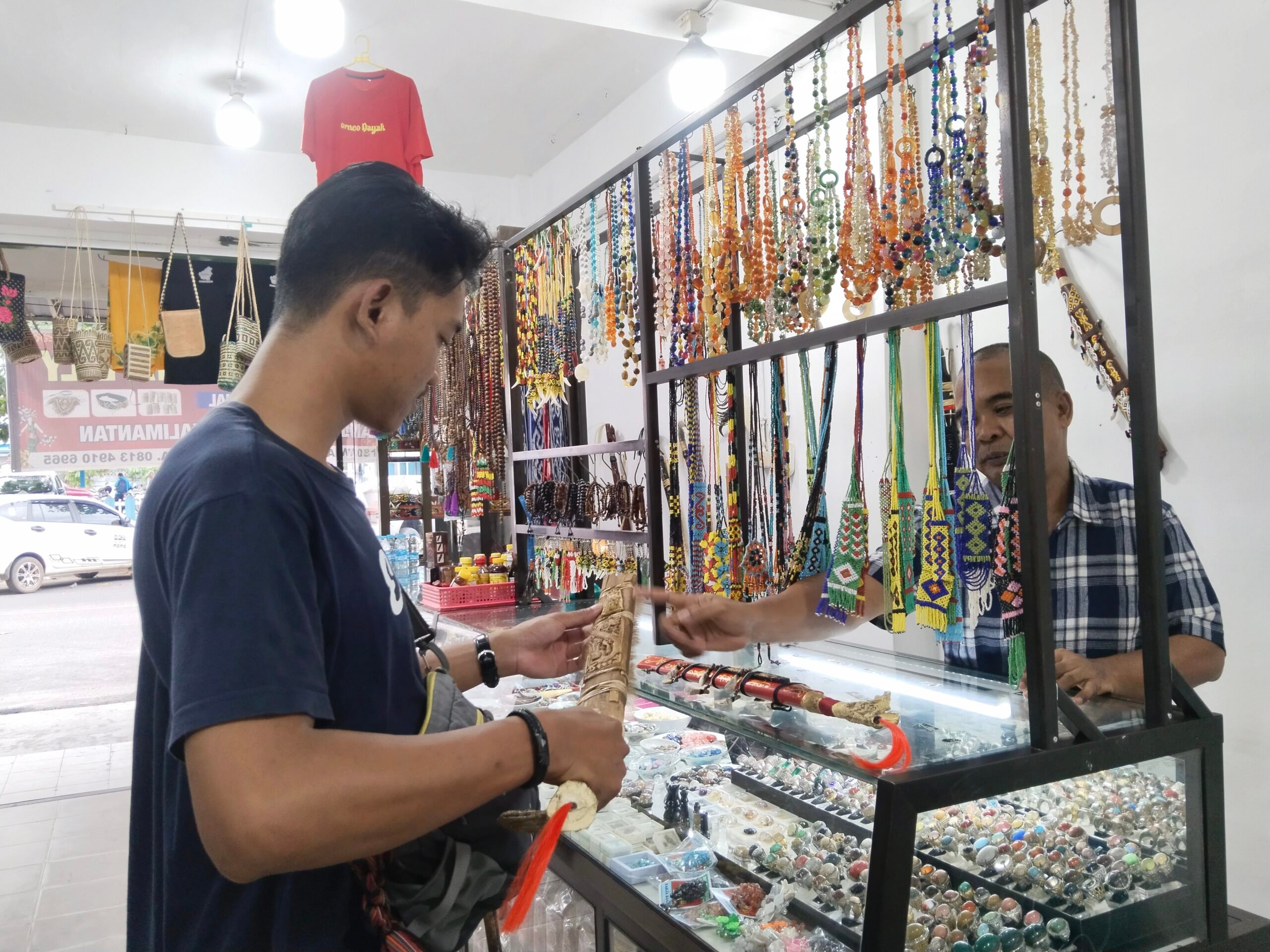 <p>Salah seorang warga asal Jogjakarta berbelanja oleh- oleh khas Dayak di Kota Sampit, Senin (14/7/2025). (Foto : Agus)</p>
