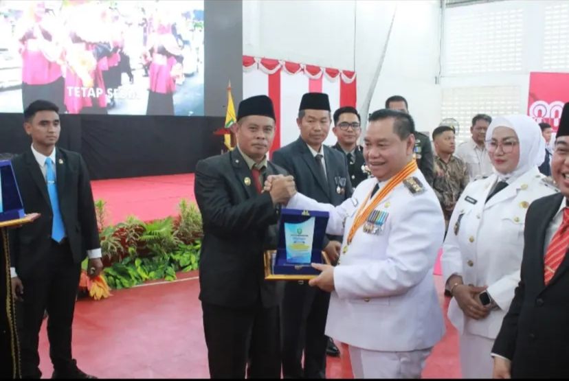 <p>Kepala Bapperida Kotim, Alang Arianto, saat menerima penghargaan dari Bupati Kotim Halikinnor. (Foto: Apri) </p>
